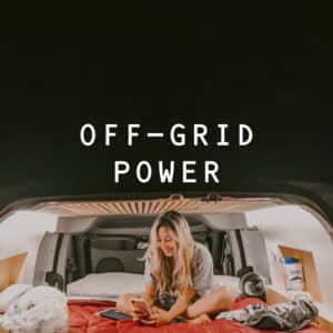 Woman on her phone in the Smalls campervan at night.