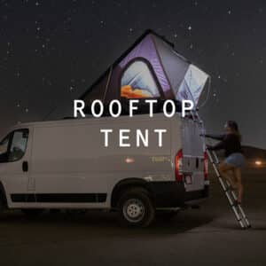 Woman climbing up a ladder in the Squad Campervan under the stars.